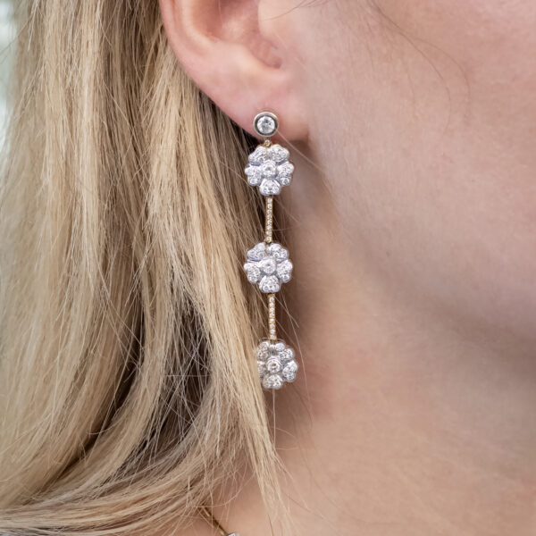 onear-diamond-white-yellow-gold-earrings Diamond floral drop earrings in 18K white and yellow gold with asymmetric flower clusters and slender connecting lines by Claris-A.