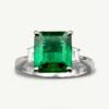 Emerald three-stone ring in 18K white gold with a 2.98-carat Colombian emerald and trapeze-cut diamonds.
