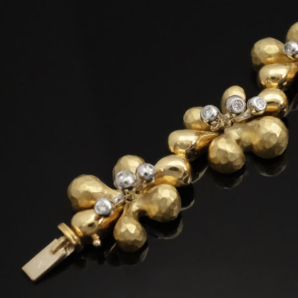 gold-diamond-floral-bracelet-claris-a.jpg Gold and diamond floral bracelet in 18K yellow gold with hammered petals, diamond-centered flowers, and smooth connecting links by Claris-A.