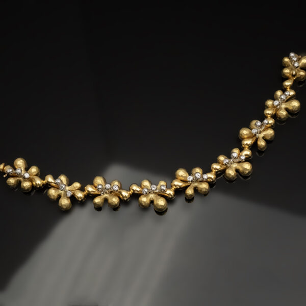 gold-diamond-floral-bracelet-claris-a.jpg Gold and diamond floral bracelet in 18K yellow gold with hammered petals, diamond-centered flowers, and smooth connecting links by Claris-A.