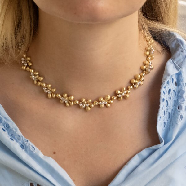 gold-diamond-floral-necklace-claris-a.jpg Gold and diamond floral necklace in 18K yellow gold with hammered petals, polished links, and alternating diamond-set and plain flowers by Claris-A.