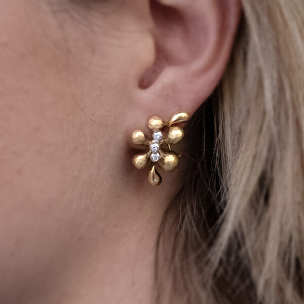 blossom-gold-earrings-claris-a.jpg Gold and diamond floral earrings in 18K yellow gold with hammered and polished petals and three small diamonds at each blossom’s center by Claris-A.