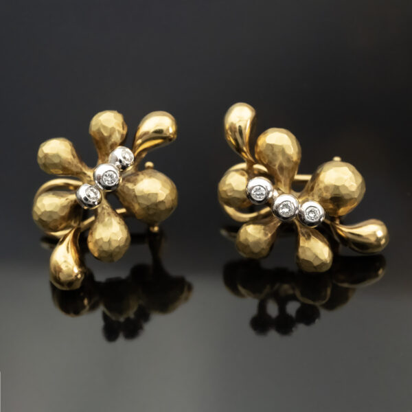 hammered-diamond-floral-earrings-claris-a.jpg Gold and diamond floral earrings in 18K yellow gold with hammered and polished petals and three small diamonds at each blossom’s center by Claris-A.