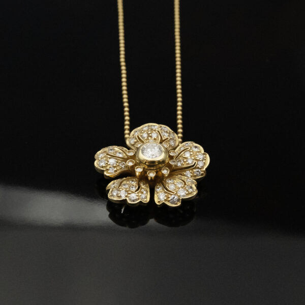diamond-flower-pendant-necklace-claris-a.jpg Diamond flower pendant necklace in 18K yellow gold with pavé-set petals and a bezel-set center diamond by Claris-A.