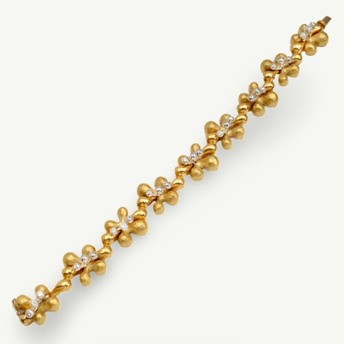 Gold and diamond floral bracelet in 18K yellow gold with hammered petals, diamond-centered flowers, and smooth connecting links by Claris-A.