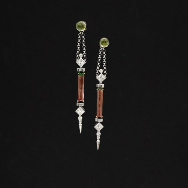 bicolor-tourmaline-diamond-earrings-claris-a.jpg White gold earrings with vertically set green-to-pink bicolor tourmalines framed by diamonds and suspended from chain links.