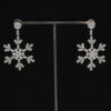 diamond-snowflake-earrings-claris-a.jpg Long 18K white gold diamond snowflake earrings with open star-shaped motifs and elongated silhouette.