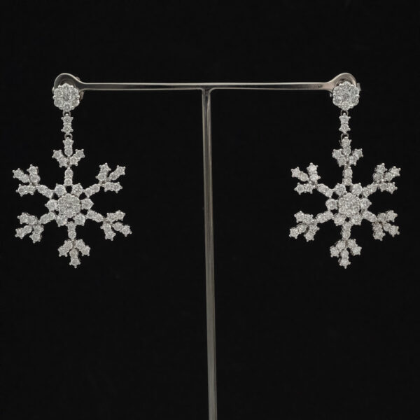 diamond-snowflake-earrings-claris-a.jpg Long 18K white gold diamond snowflake earrings with open star-shaped motifs and elongated silhouette.