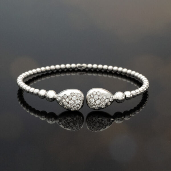 18K white gold diamond cuff bracelet with articulated bead structure and teardrop diamond caps