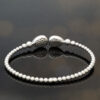 diamond-cuff-bracelet-18k-white-gold.jpg 18K white gold diamond cuff bracelet with articulated bead structure and teardrop diamond caps