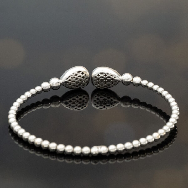 diamond-cuff-bracelet-18k-white-gold.jpg 18K white gold diamond cuff bracelet with articulated bead structure and teardrop diamond caps