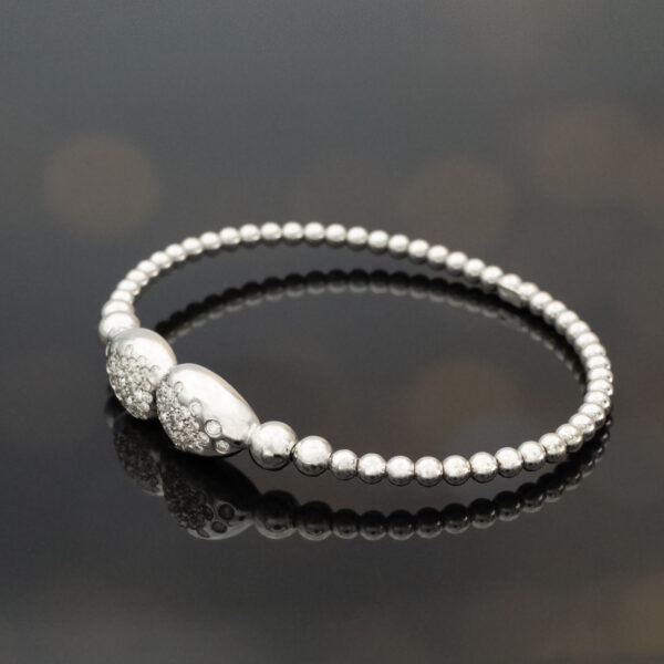 18K white gold diamond cuff bracelet with articulated bead structure and teardrop diamond caps