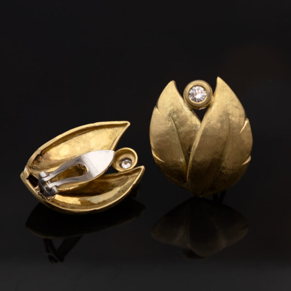 hammered-gold-leaf-diamond-earrings.jpg Hammered yellow gold leaf earrings with an open tip design, each set with a single diamond suspended between the curved terminals.