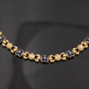 5744 Articulated 18K yellow gold bracelet with rounded links and raised floral motifs set with sapphires and diamonds in a fluid design.