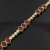 YellowGold_LinkBracelet_With_Ruby Articulated 18K yellow gold link bracelet set with rubies and diamonds, featuring sculptural geometric links arranged in a fluid line.