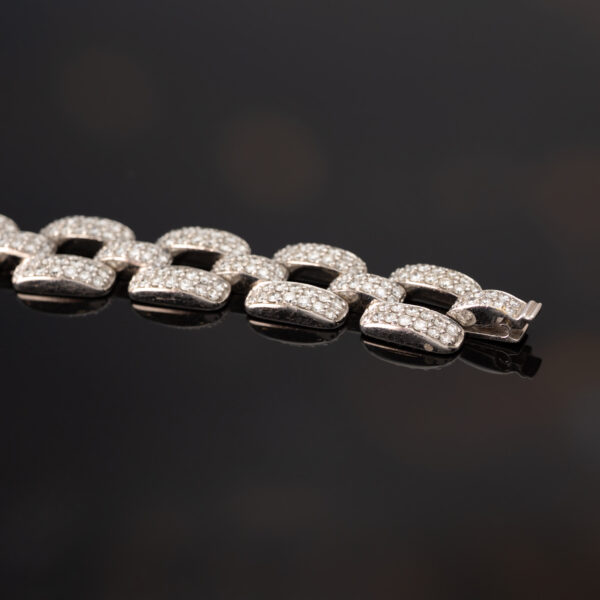 Articulated 18K white gold bracelet composed of rectangular diamond-set links with open centres and a graphic, structured design.