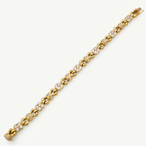 Diamond Floral Link Bracelet in 18K Yellow Gold Articulated 18K yellow gold bracelet with rounded links and raised floral motifs set with diamonds, forming a fluid, polished design.