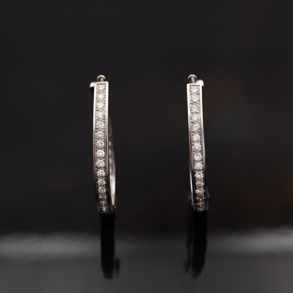White gold oval hoop earrings with brilliant-cut diamonds in a single row