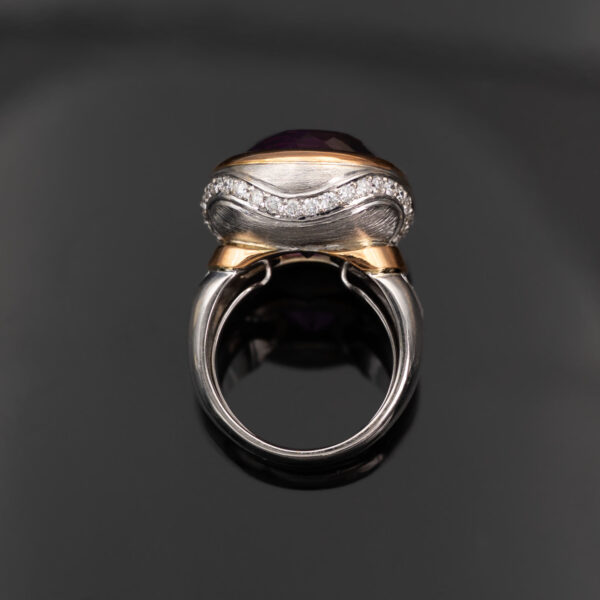 Claris-A-amethyst-diamond-cocktail-ring-white-yellow-gold-side 18K white and yellow gold cocktail ring with a large round purple amethyst in a yellow gold bezel, diamonds set along the gallery and shoulders, side view