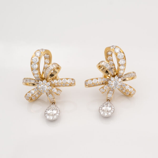 8K yellow gold ribbon bow earrings set with baguette and brilliant-cut diamonds, featuring pear-shaped diamond drops