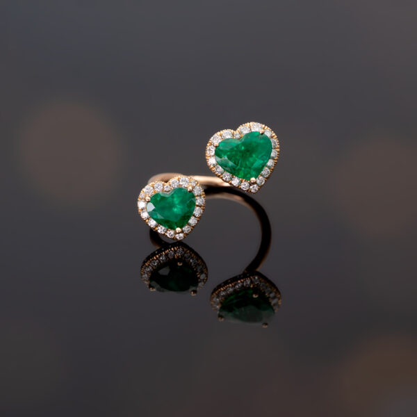 Rose gold toi et moi ring with two heart-shaped Colombian emeralds and diamond halo settings