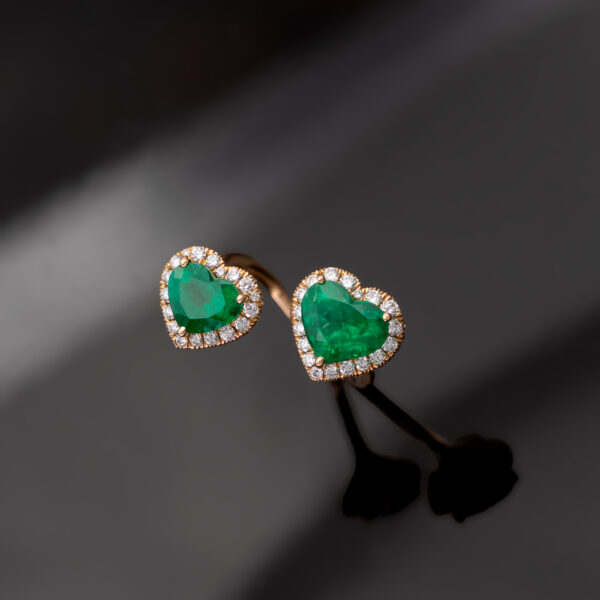 Rose gold toi et moi ring with two heart-shaped Colombian emeralds and diamond halo settings