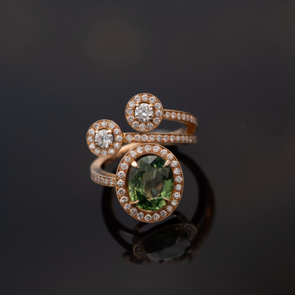 ClarisA_Gold_Ring_18K 18K rose gold openwork ring with oval green sapphire and diamond halo, sculptural asymmetrical wrap design