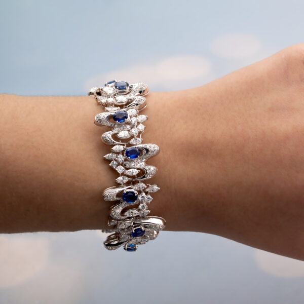 White gold bracelet with oval blue sapphires and diamond-set articulated links in a sculptural design