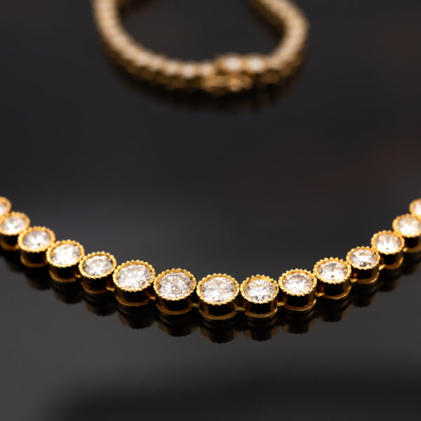 Milgrain Diamond Tennis Necklace Yellow Gold 18k yellow gold tennis necklace with graduated round diamonds in a milgrain setting.