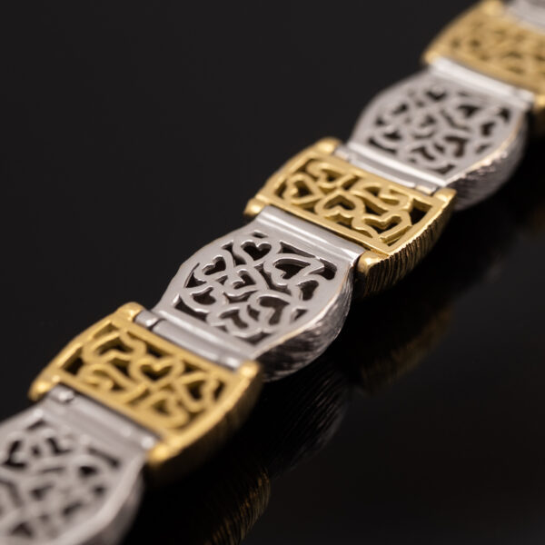 Italian Dual-Tone Gold Sculptural Bracelet Italian 18K white and yellow gold sculptural bracelet with textured engraved links, rounded connectors, and heart motifs on reverse.