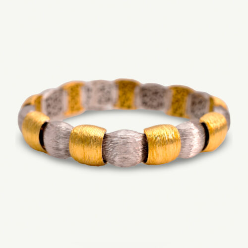 Italian Dual-Tone Gold Sculptural Bracelet Italian 18K white and yellow gold sculptural bracelet with textured engraved links, rounded connectors, and heart motifs on reverse.