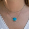 Turquoise Tsavorite Diamond Sunburst Necklace in White Gold White gold pendant necklace with oval turquoise centre surrounded by tsavorites and diamonds in a floral sunburst motif.
