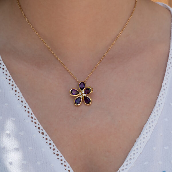Amethyst Flower Pendant in 18K Yellow Gold 18K yellow gold flower pendant set with five pear-cut amethysts surrounding a diamond-set centre.