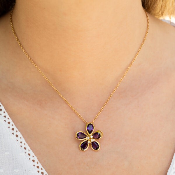 Amethyst Flower Pendant in 18K Yellow Gold 18K yellow gold flower pendant set with five pear-cut amethysts surrounding a diamond-set centre.