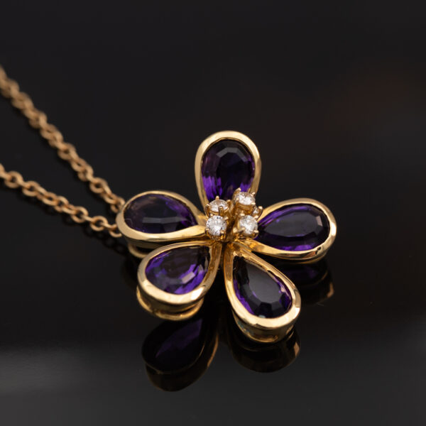Amethyst Flower Pendant in 18K Yellow Gold 18K yellow gold flower pendant set with five pear-cut amethysts surrounding a diamond-set centre.