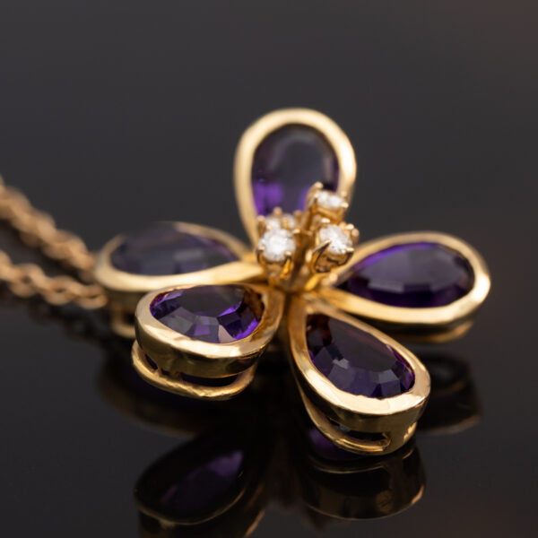 18K yellow gold flower pendant set with five pear-cut amethysts surrounding a diamond-set centre.