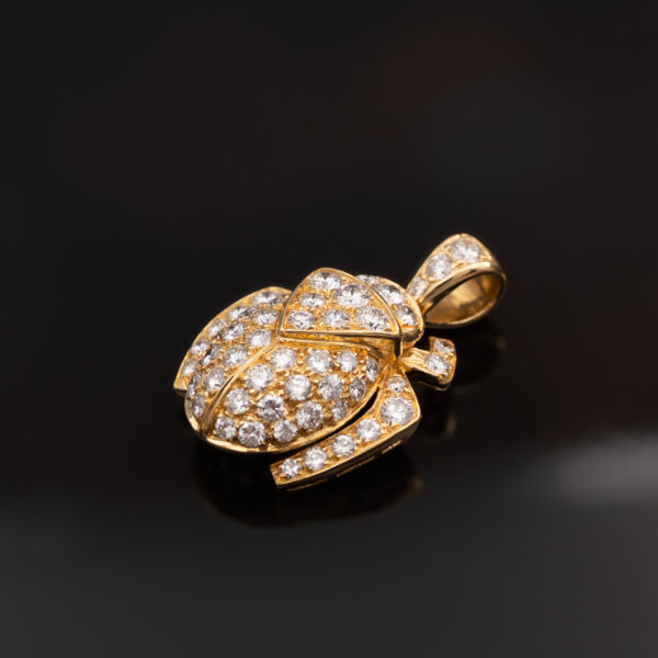 Diamond Scarab Pendant in 18K Yellow Gold Sculptural 18K yellow gold scarab pendant set with diamonds, featuring a domed beetle design with geometric detailing and high-jewelry finish.