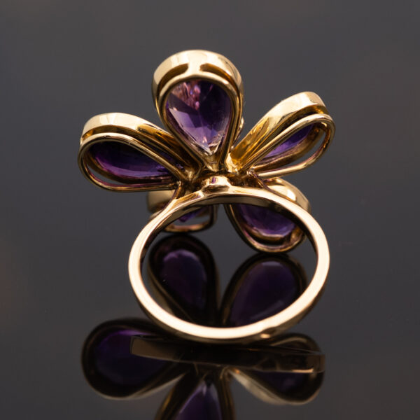 Amethyst Flower Ring in 18K Yellow Gold 18K yellow gold flower ring set with five pear-cut amethysts surrounding a diamond-set centre.