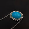 Turquoise Tsavorite Diamond Sunburst Necklace in White Gold White gold pendant necklace with oval turquoise centre surrounded by tsavorites and diamonds in a floral sunburst motif.