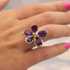 Amethyst Flower Ring in 18K Yellow Gold 18K yellow gold flower ring set with five pear-cut amethysts surrounding a diamond-set centre.