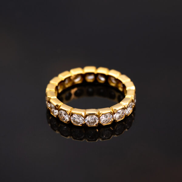 18K yellow gold eternity ring with round brilliant-cut diamonds in hexagonal gold settings.