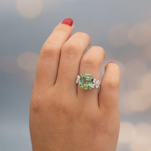 Green Tourmaline Blossom Ring in 18K White Gold 18K white gold ring with a cushion-shaped green tourmaline surrounded by pear-shaped and brilliant-cut diamonds in a floral-inspired setting.