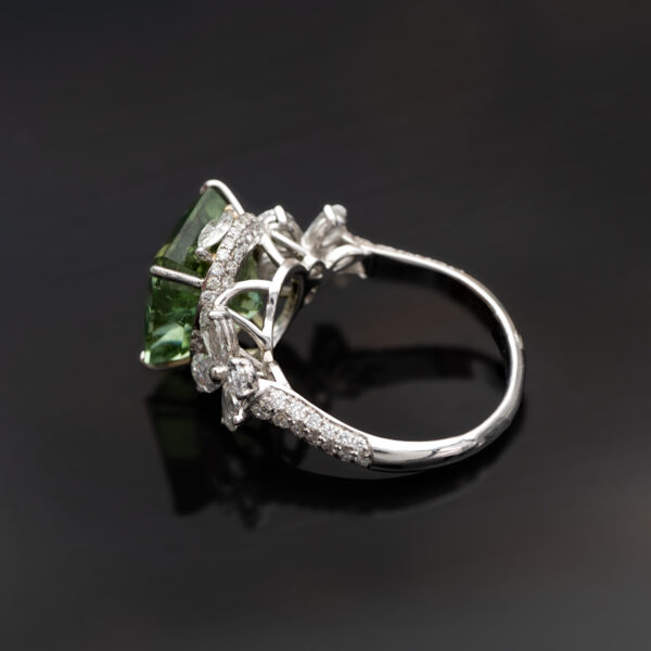 Green Tourmaline Blossom Ring in 18K White Gold 18K white gold ring with a cushion-shaped green tourmaline surrounded by pear-shaped and brilliant-cut diamonds in a floral-inspired setting.