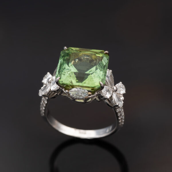 Green Tourmaline Blossom Ring in 18K White Gold 18K white gold ring with a cushion-shaped green tourmaline surrounded by pear-shaped and brilliant-cut diamonds in a floral-inspired setting.