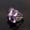 Amethyst Flower Ring in 18K White Gold 18K white gold flower ring with four amethyst cabochons and a diamond centre.